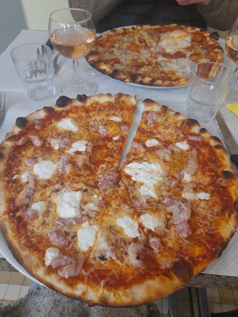 Deux pizzas posées au centre d’une table